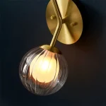 Wall light in satin brass finish with clear ribbed glass