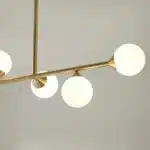Satin brass linear pendant light with gloss opal glass shades angle