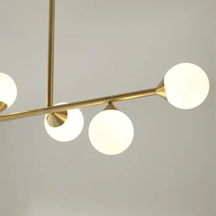 Satin brass linear pendant light with gloss opal glass shades angle