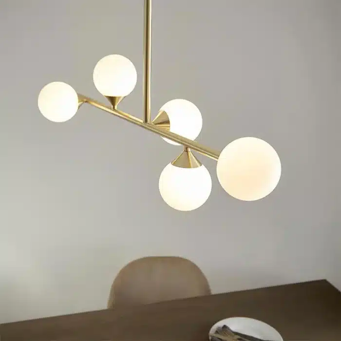 Satin brass linear pendant light with gloss opal glass shades close up