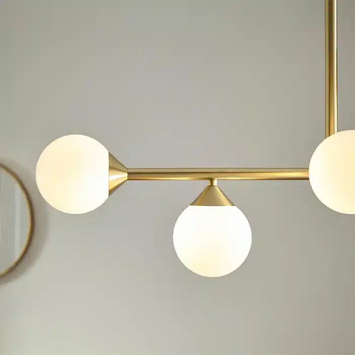 Satin brass linear pendant light with gloss opal glass shades side view
