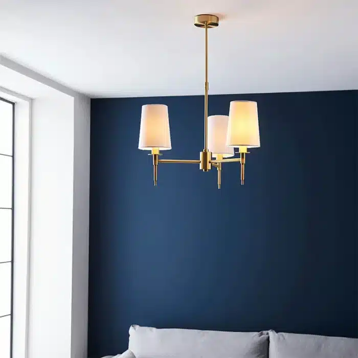 Satin brass pendant light with vintage white shades close up living room