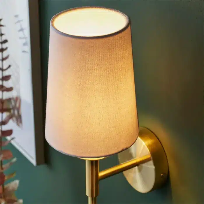 Satin brass wall light with vintage white fabric shade top angle